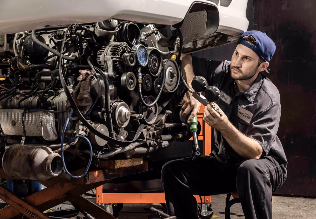 Technician working on an exposed engine assembly at Euro Spec Motoring