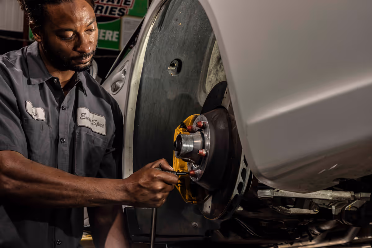 Technician servicing a Porsche brake and hub assembly
