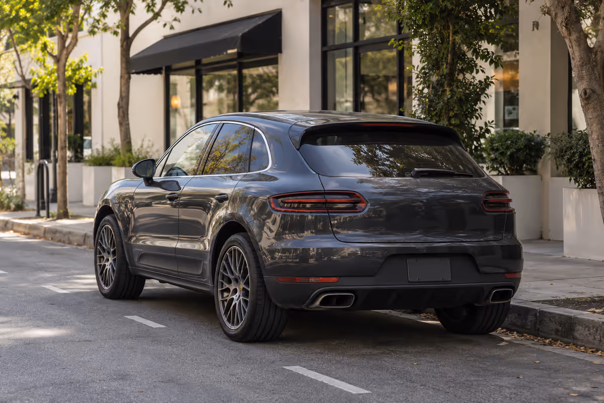 Dark Porsche Macan parked on a quiet city street
